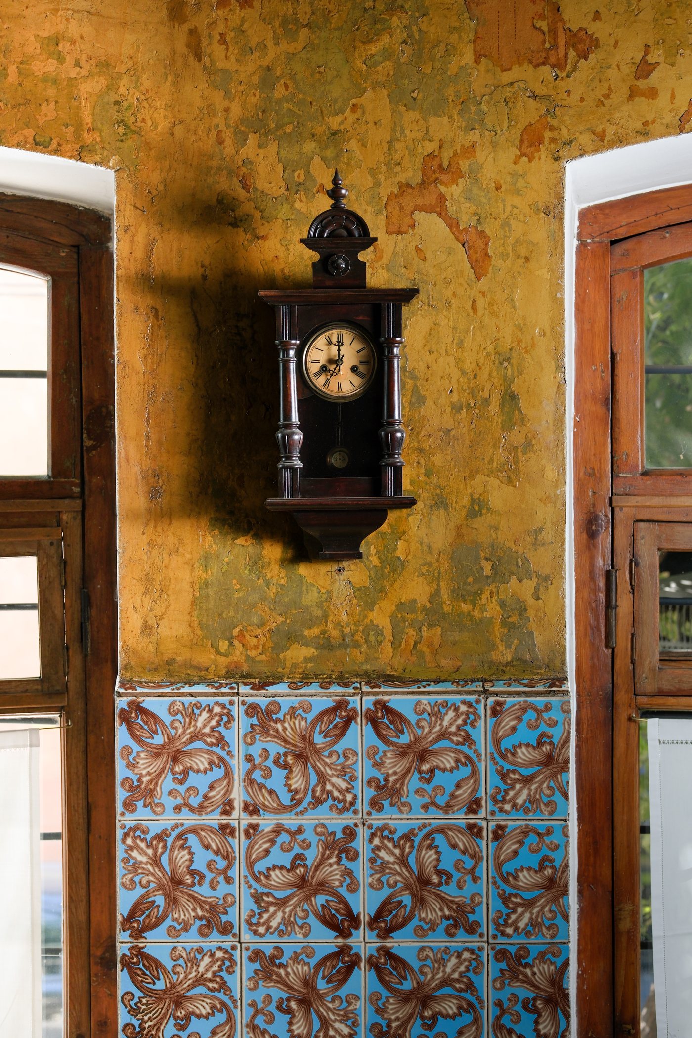 Old Armenian tile wall with clock and candlelight