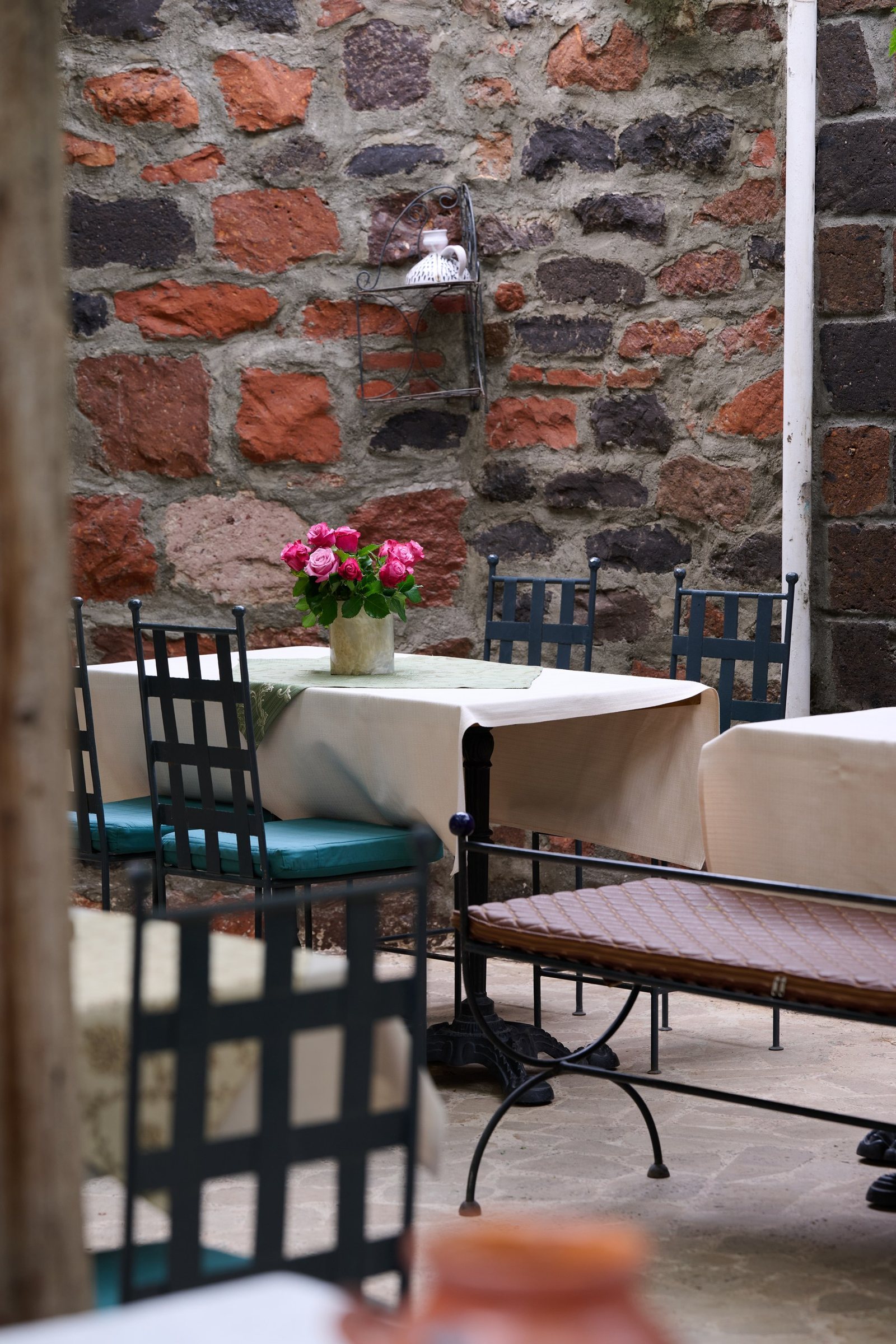 Brick courtyard corner with cafe chairs and Armenian greenery