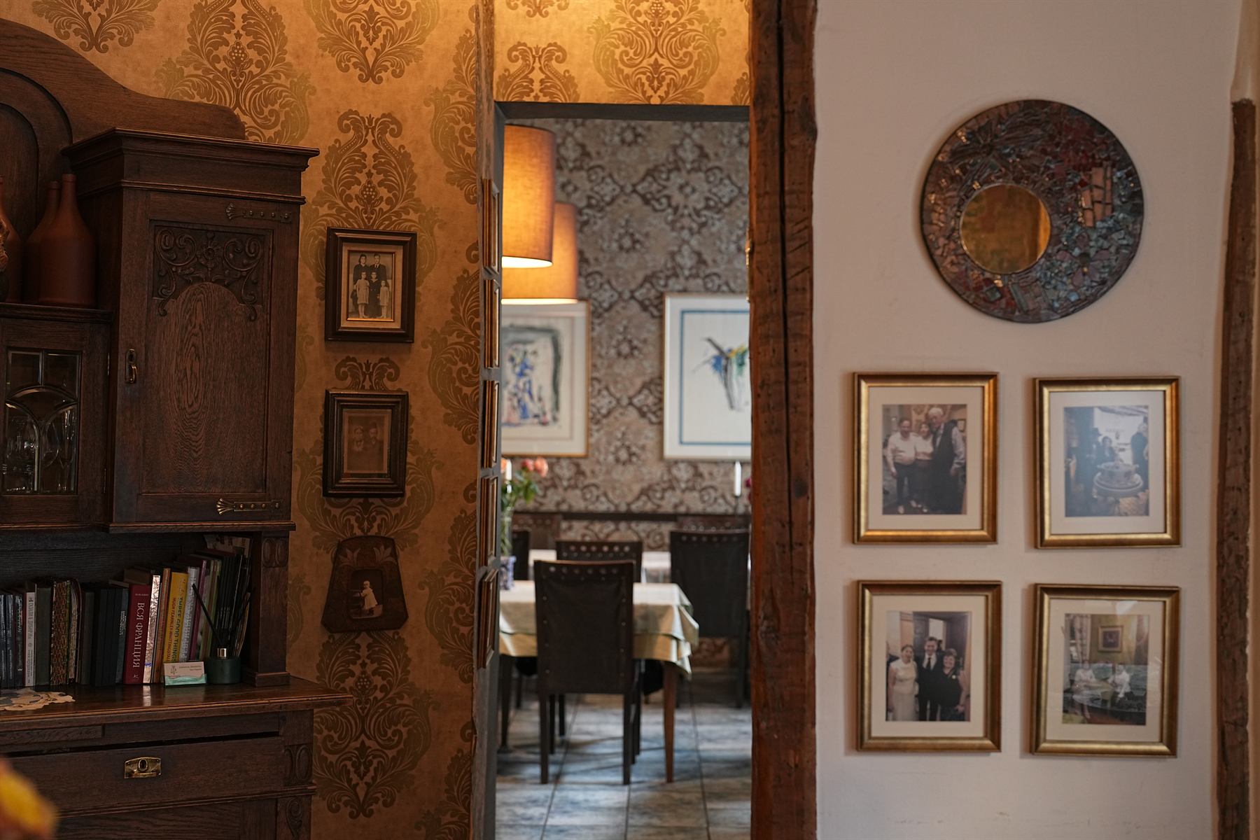 Dolmama interior doorway with framed family photographs and warm wallpaper