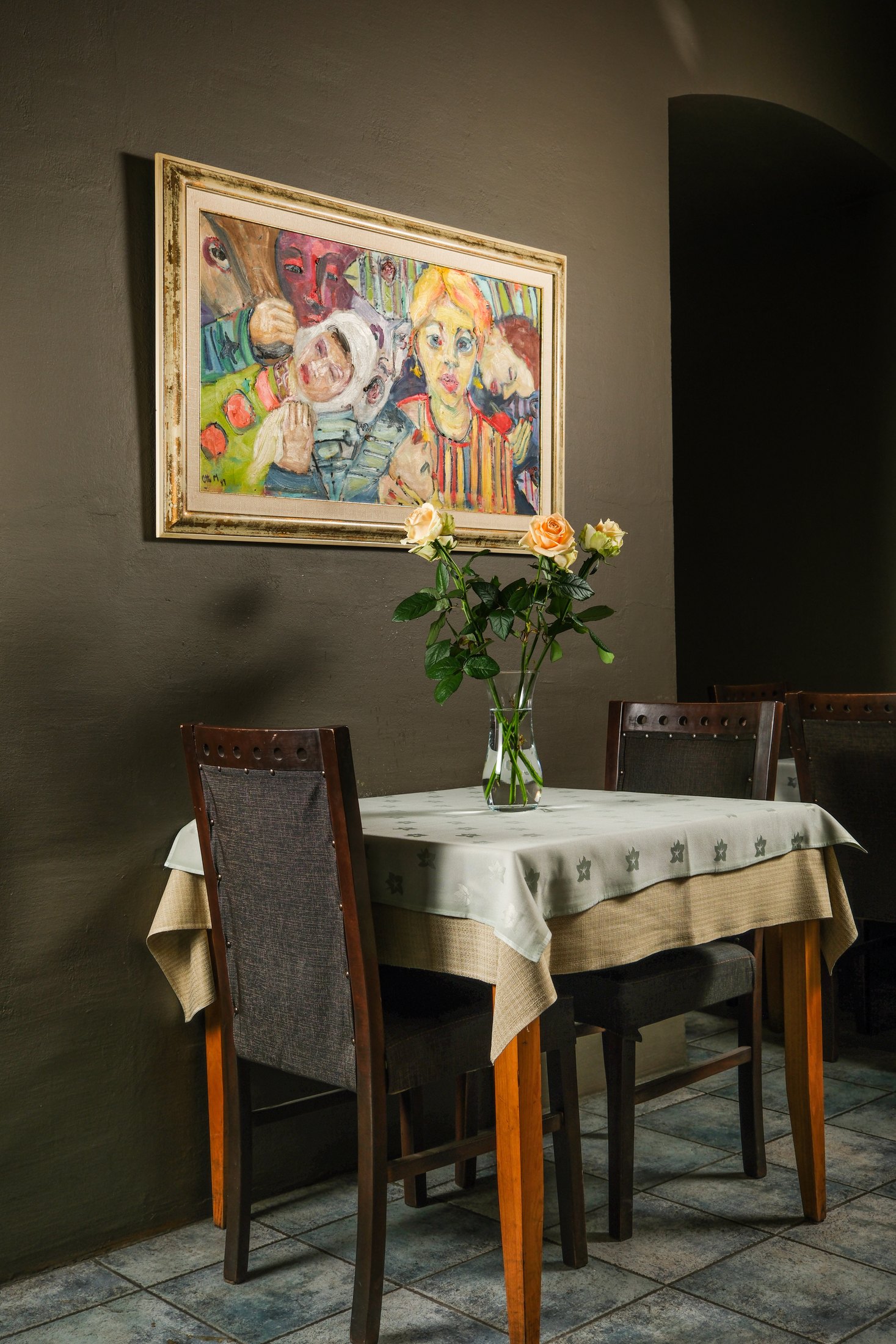 Quiet Dolmama table with roses beneath framed artwork